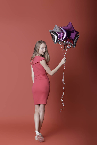 Woman in red dress holding balloons. - Photo, Image