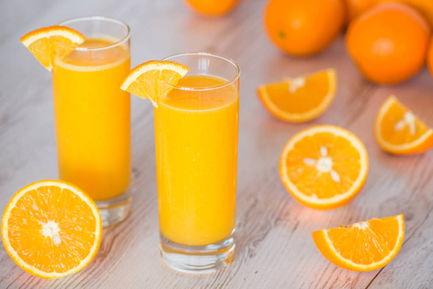 narancslé az üvegeken, világos fából készült háttér - Fotó, kép