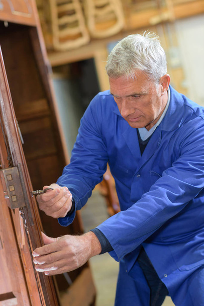 senior carpenter restoring old furniture - Foto, afbeelding