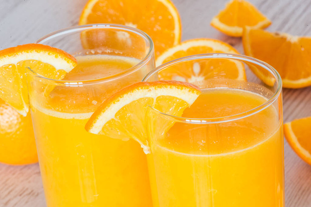 succo d'arancia in bicchieri su sfondo di legno chiaro
 - Foto, immagini