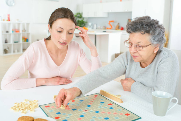 Elderly woman playing a board game - Photo, Image