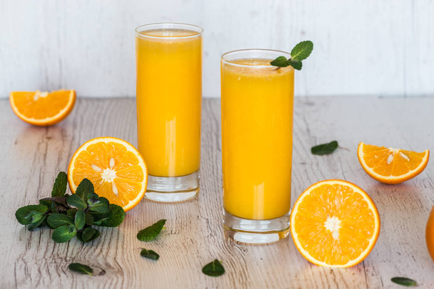 succo d'arancia con menta in bicchieri su sfondo di legno chiaro
 - Foto, immagini