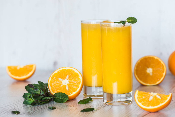 succo d'arancia con menta in bicchieri su sfondo di legno chiaro
 - Foto, immagini