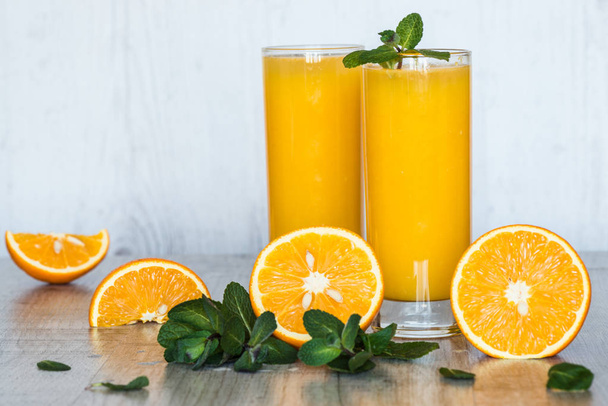 апельсиновый сок с мятой в стаканах на светлом деревянном фоне
 - Фото, изображение