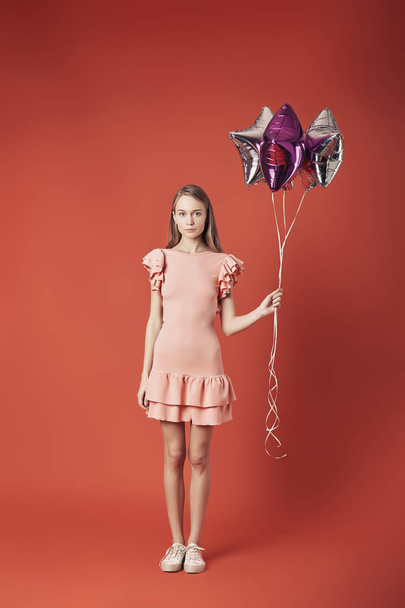 Woman in red dress holding balloons. - Foto, imagen