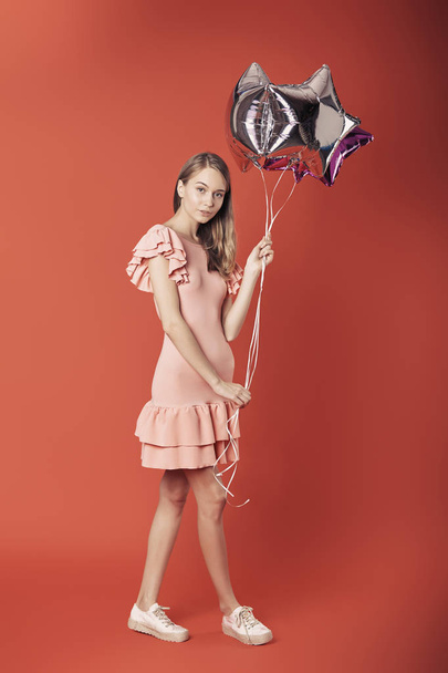Woman in red dress holding balloons. - Foto, immagini