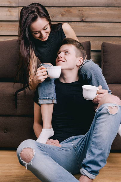 Beautiful guy with girl sitting next to and drinking coffee - Zdjęcie, obraz