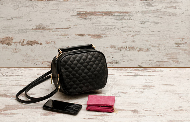 小さな黒い女性バッグ、財布と携帯電話。ファッショナブルな概念 - 写真・画像