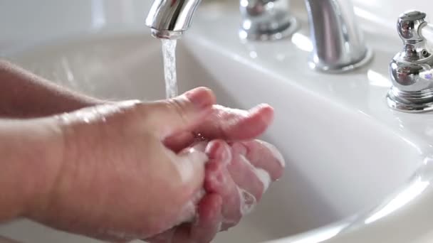 Clip de cámara lenta del hombre lavándose las manos en el lavabo del baño
 - Metraje, vídeo