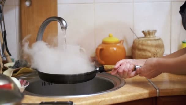 ウォッシュ熱いフライパン家庭の台所のシンクの蒸気に冷水のジェットになります。スローモーション - 映像、動画
