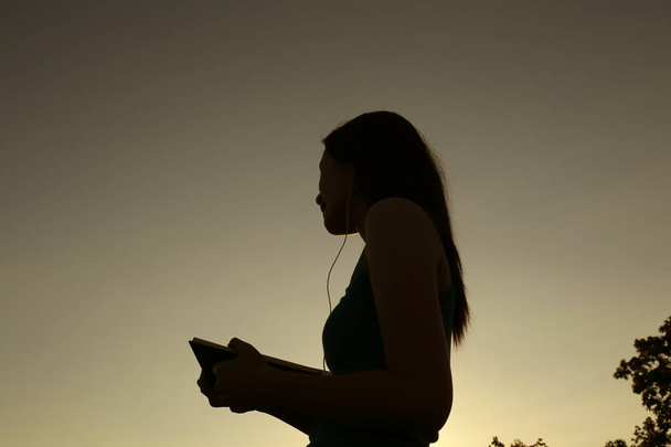 Silueta mujer al aire libre puesta de sol en el parque
 - Foto, imagen
