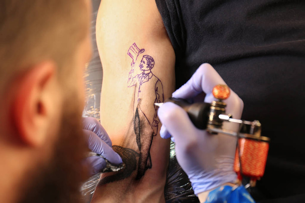 Professional artist making tattoo in salon, close up view - Zdjęcie, obraz