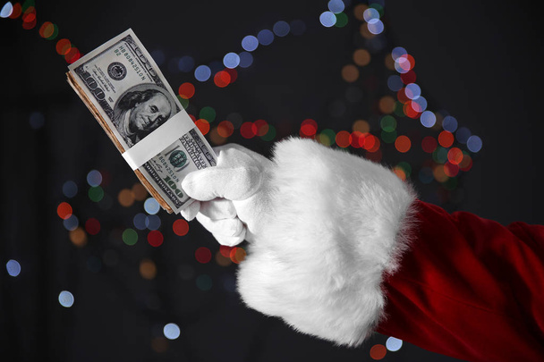 Santa Claus hand holding money  - Foto, Imagen