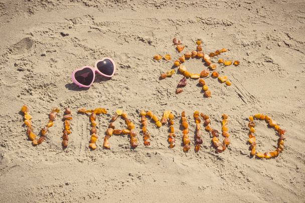 Sunglasses, inscription vitamin D and shape of sun on sand at beach, summer time and healthy lifestyle - Fotoğraf, Görsel