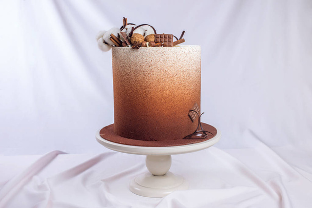 Pastel de chocolate de boda espolvoreado con cacao y nueces, canela
 - Foto, Imagen