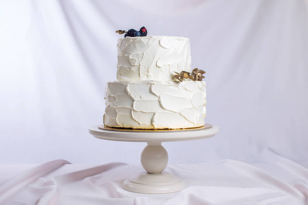 білий крем торт прикрашений гілкою з золотим листям
 - Фото, зображення