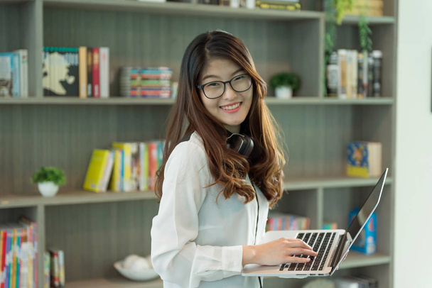 Dziewczyna azjatyckich firm za pomocą laptopa w bibliotece w biurze, osoba - Zdjęcie, obraz