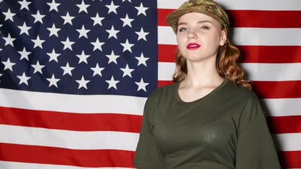  Χαμογελαστό κορίτσι στρατιώτες με μακιγιάζ χαιρετισμό μπροστά μας σημαία - Πλάνα, βίντεο