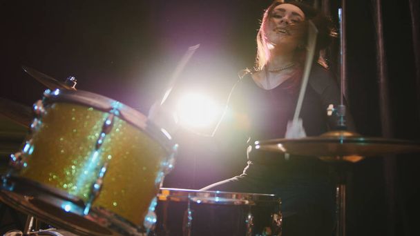 Gothic κορίτσι κρουστά ντράμερ εκτέλεση μουσικής διάλειμμα κάτω - Rock μπάντα πρόβες στο γκαράζ - Φωτογραφία, εικόνα