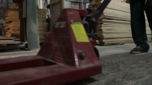 Carpintero trabajando con plataforma de carretilla elevadora manual
 - Metraje, vídeo