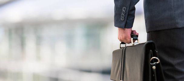 businessman holding a leather briefcase - Foto, afbeelding