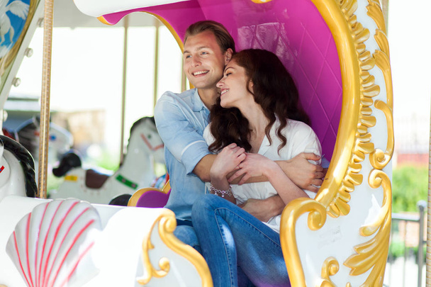 couple embracing while riding on a merry-go-round - 写真・画像
