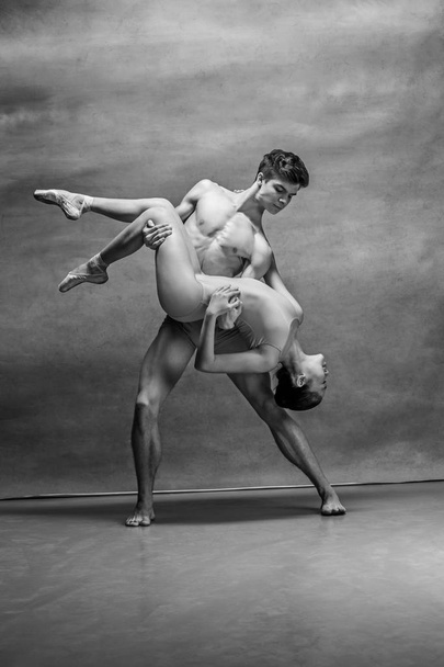 Couple of ballet dancers posing over gray background - Fotografie, Obrázek
