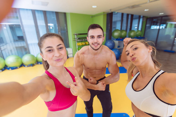 Groupe de personnes dans une salle de gym prenant selfie
 - Photo, image