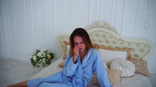 Femmes de mauvaise humeur, bouleversées et pleurant, assises sur le lit dans des chambres spacieuses
. - Séquence, vidéo