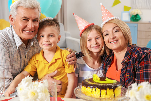 Πάρτι γενεθλίων. Οικογένεια κάθεται στο τραπέζι σερβίρεται - Φωτογραφία, εικόνα