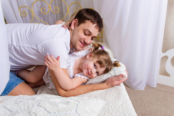 Vader en dochter spelen op het bed  - Foto, afbeelding