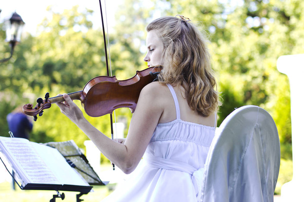  Музикант на весілля. Красива усміхнена дівчина кричить на відкритому повітрі. Скрипка під небом
 - Фото, зображення