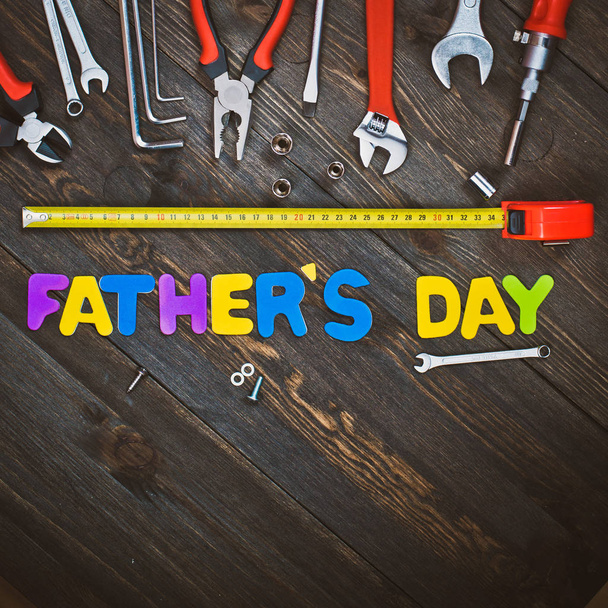 Buchstaben und Werkzeuge hölzerner Hintergrund Vatertag - Foto, Bild
