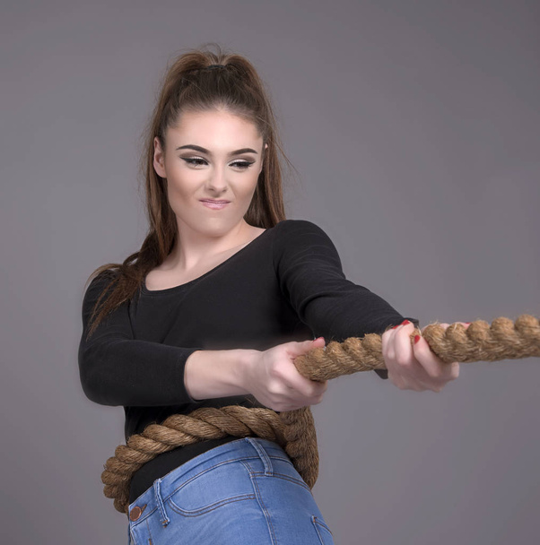 Tug of war concept with girl pulling a rope - Фото, зображення
