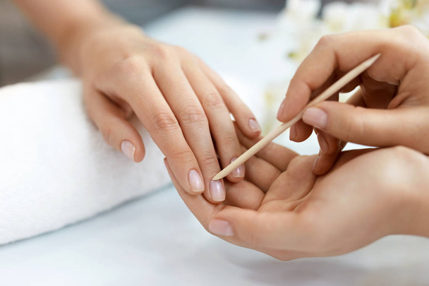 Nail Salon. Closeup Of Female Hands With Wooden Stick. Manicure - Фото, зображення