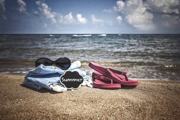 Летний фон с шлепанцами и солнцезащитными очками на пляже
 - Фото, изображение