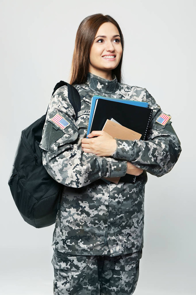 Pretty female cadet of military school on grey background - Foto, Imagen