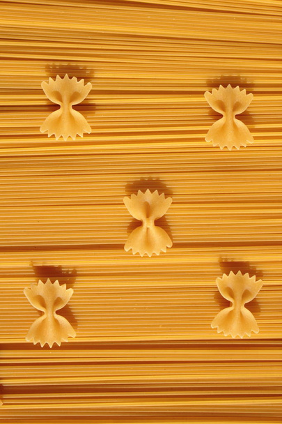 Pasta bows placed on spaghetti. - Фото, зображення