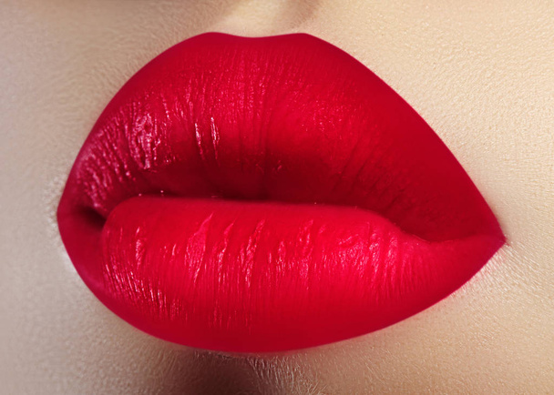 Косметика, макияж. Яркая помада на губах. Крупный план красивого женского рта с красным макияжем губ. Сладкий поцелуй
 - Фото, изображение