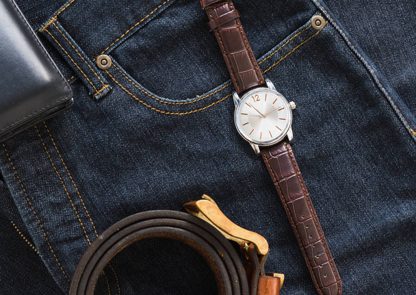 Wristwatch and wallet on denim jeans pocket - 写真・画像