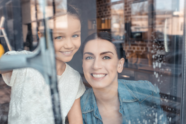 Mother and daughter cleaning window  - Photo, Image