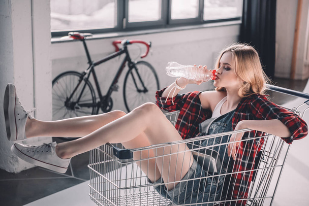 Young woman with shopping cart  - Valokuva, kuva