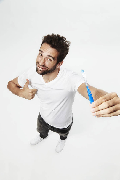 Gap toothed man with toothbrush  - 写真・画像