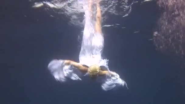 Underwater model free diver in costume angel swims in clean water in Red Sea. - Záběry, video