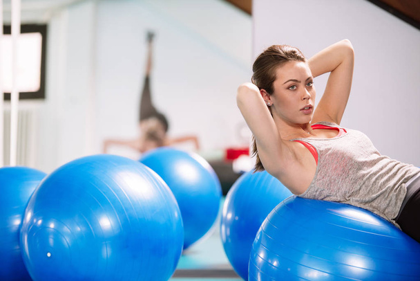 Exercício de mulher jovem com bola pilates
 - Foto, Imagem