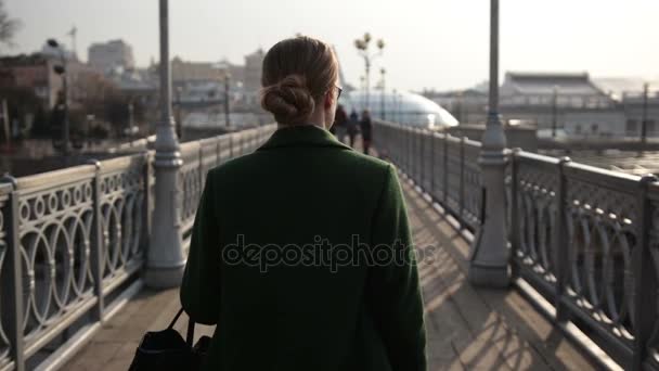Takaisin näkymä nainen kävelee pois sillalla
 - Materiaali, video