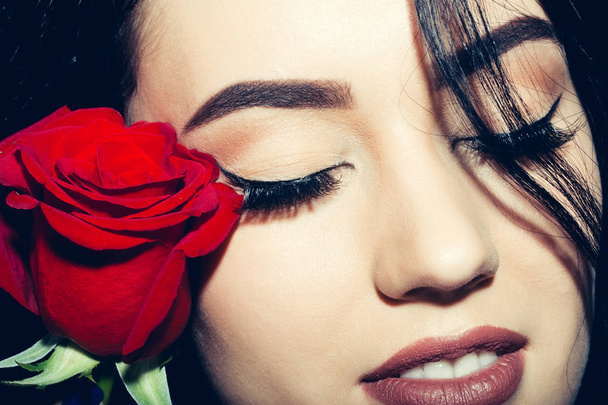 Красива дівчина з закритими очима і червоною трояндою
 - Фото, зображення