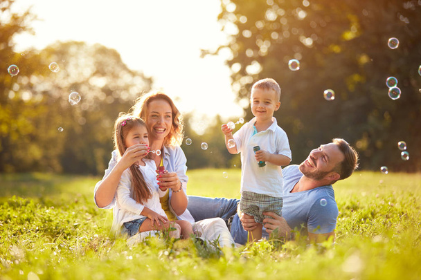 Family with children blow soap bubbles  - Foto, imagen