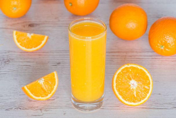 zumo de naranja en vidrio sobre fondo de madera claro
 - Foto, Imagen