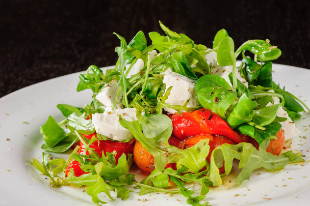Warm salad with Tomatoes, ruccola, spinach, cooked bell pepper and cheese - Photo, image